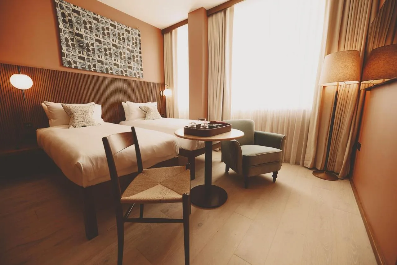 a hotel room with two beds and a table and a chair at Mollie's Manchester in Manchester