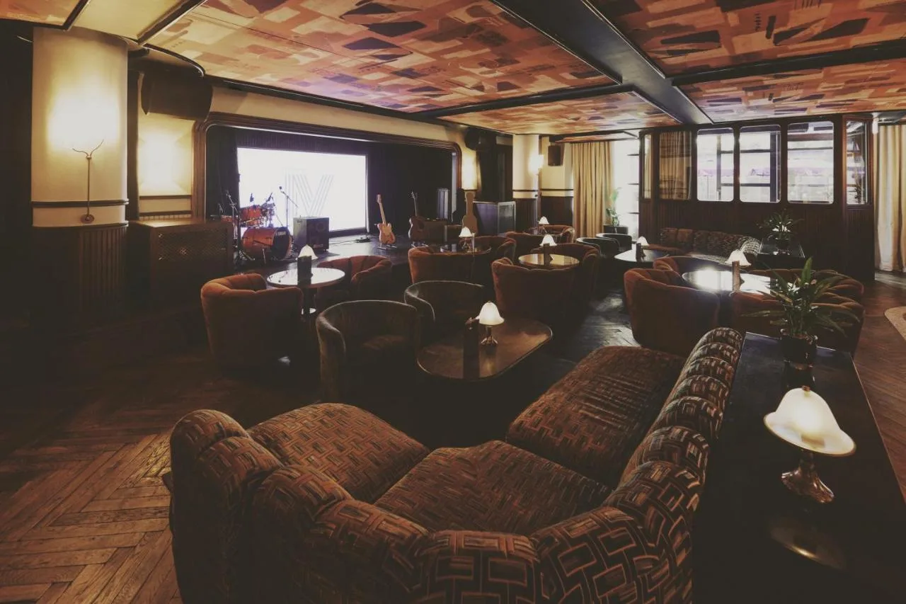 a living room with couches and a large screen at Mollie's Manchester in Manchester