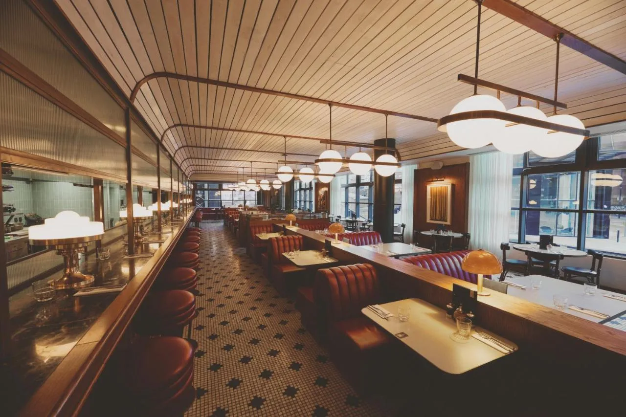 a restaurant with many tables and chairs and lights at Mollie's Manchester in Manchester