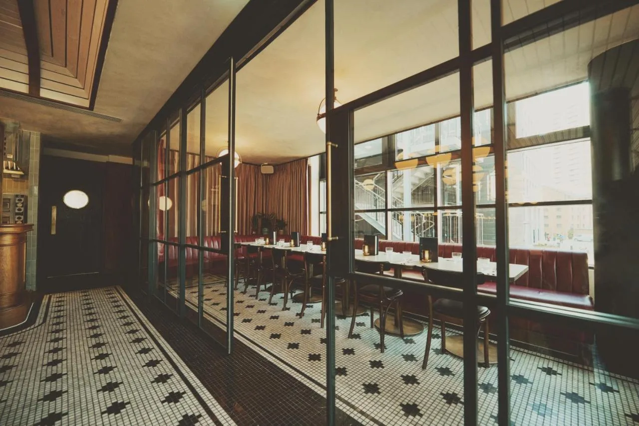 a restaurant with tables and chairs in a room with windows at Mollie's Manchester in Manchester